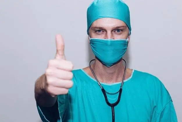 Doctor in scrubs giving a 'thumbs up'