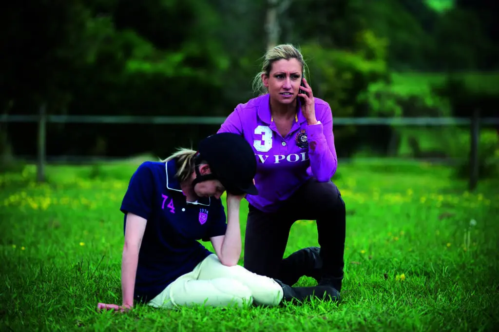 Horse rider phoning for help, casualty head in hands