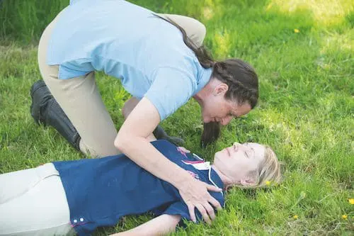 Someone checking an unconscious casualty