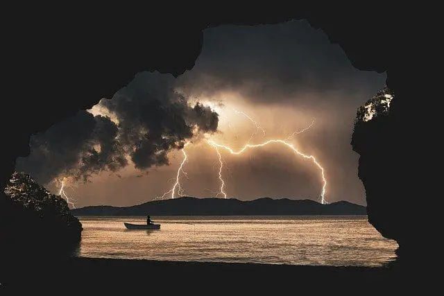 view of lightning and kayaker on a loch