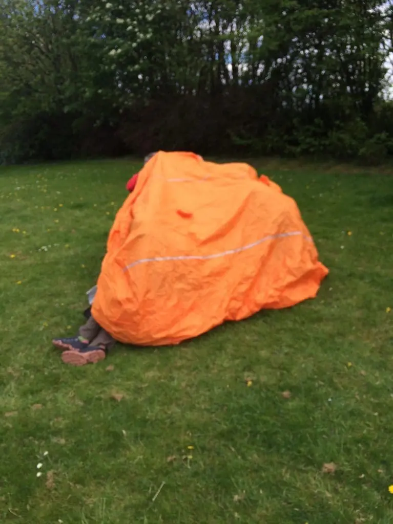 Legs poking out a large orange safety blanket