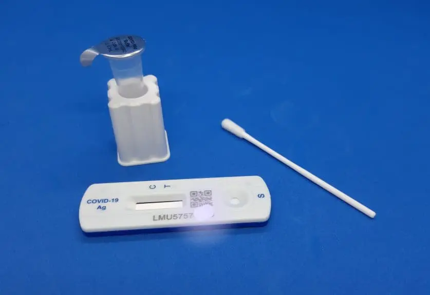 A lateral flow test kit with vial, swab and test cassette.