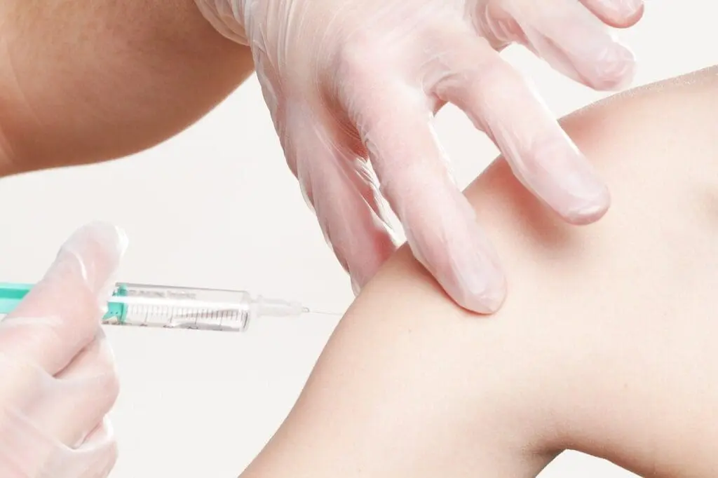 A vaccination needle going into an arm