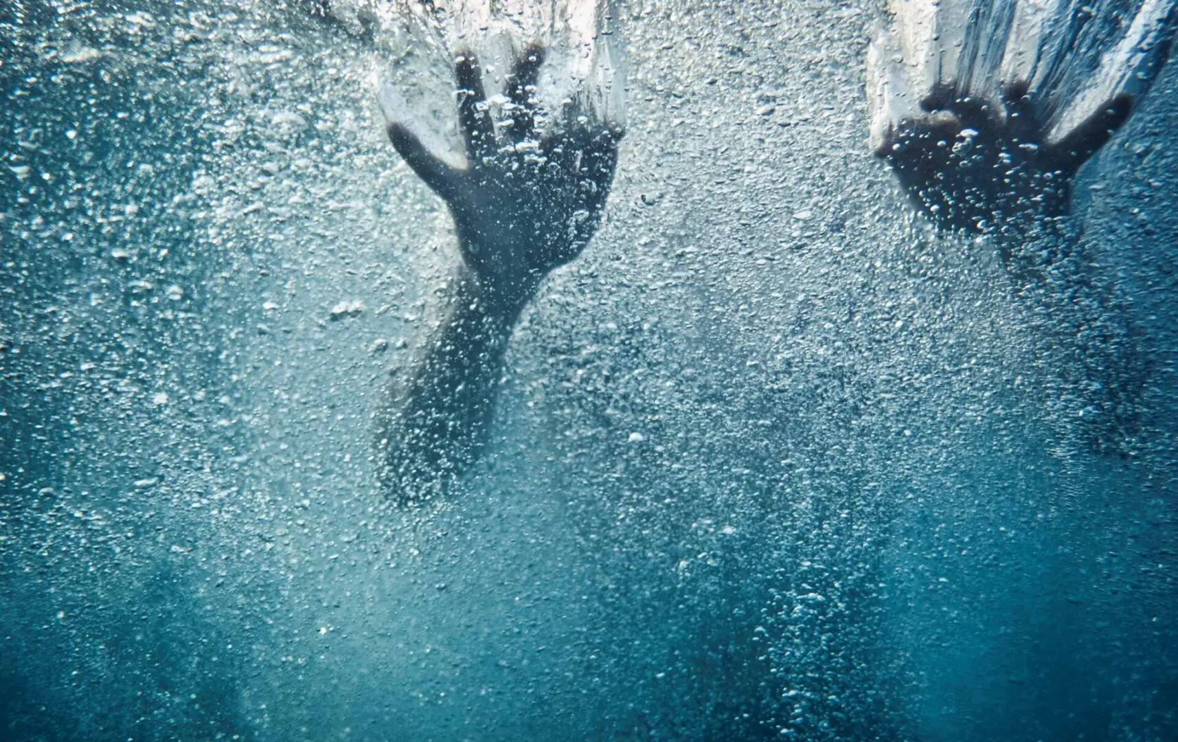 Two hands under water after falling in