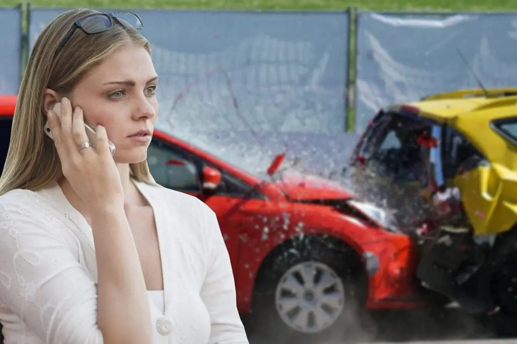 A woman making a phone call after a car accident