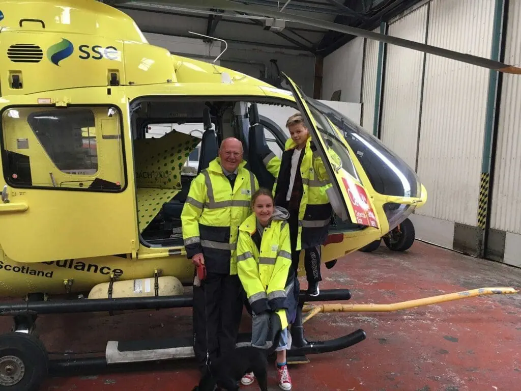 Mike Beale with children next to a SCAA helicopter