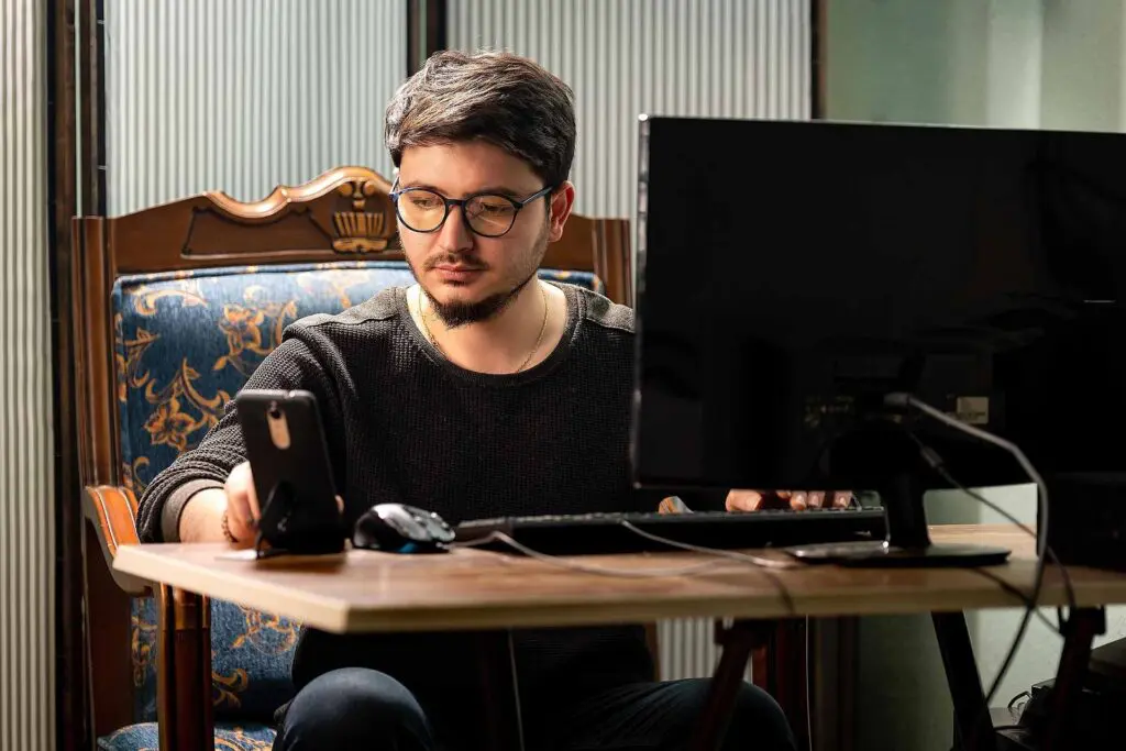 A man in a home office with a PC and phone