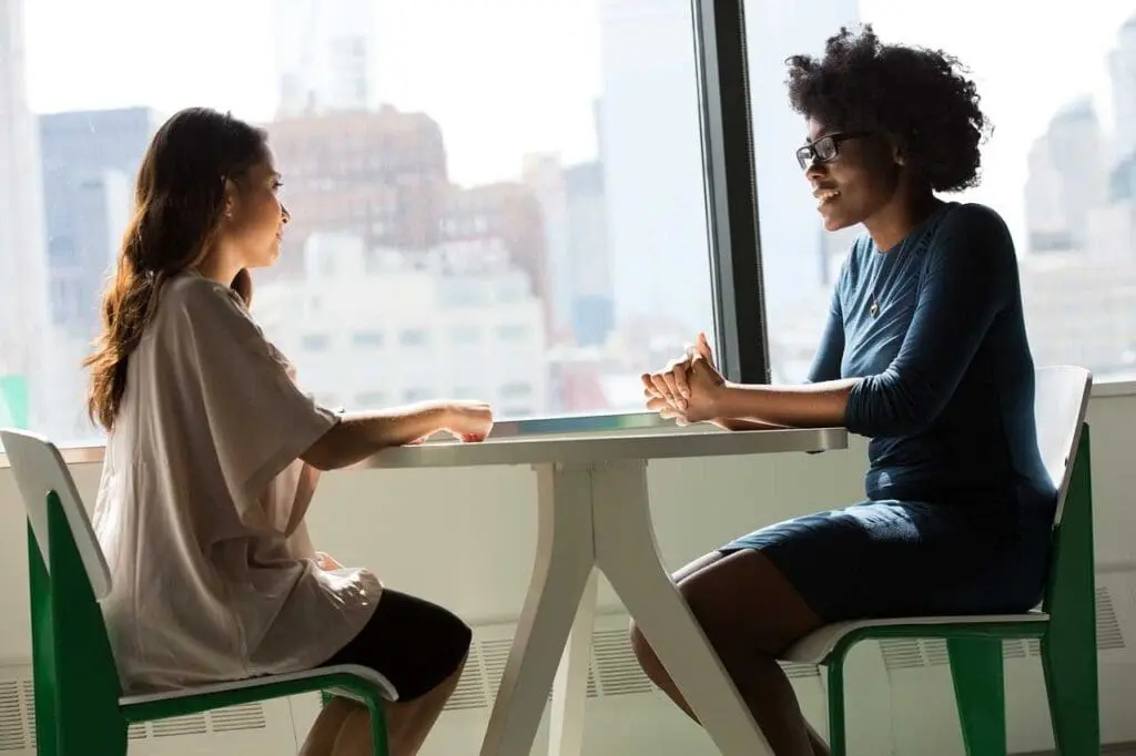 Two women in a meeting by a sunny window