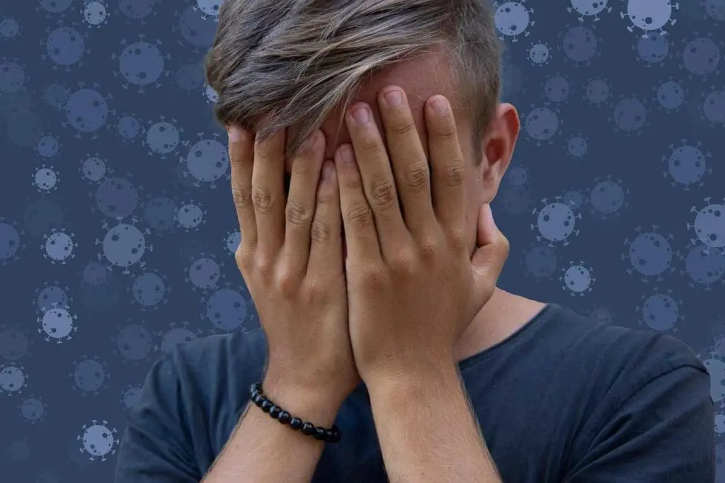 A boy with his head in his hands, mental heath