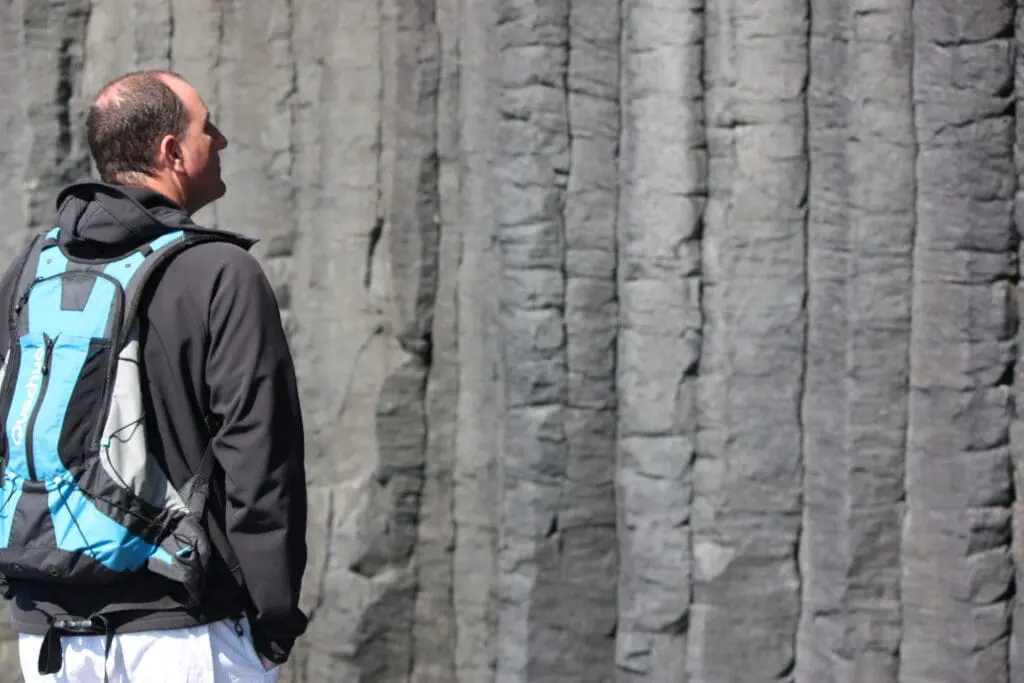 A man alone looking at some geology  outdoors 