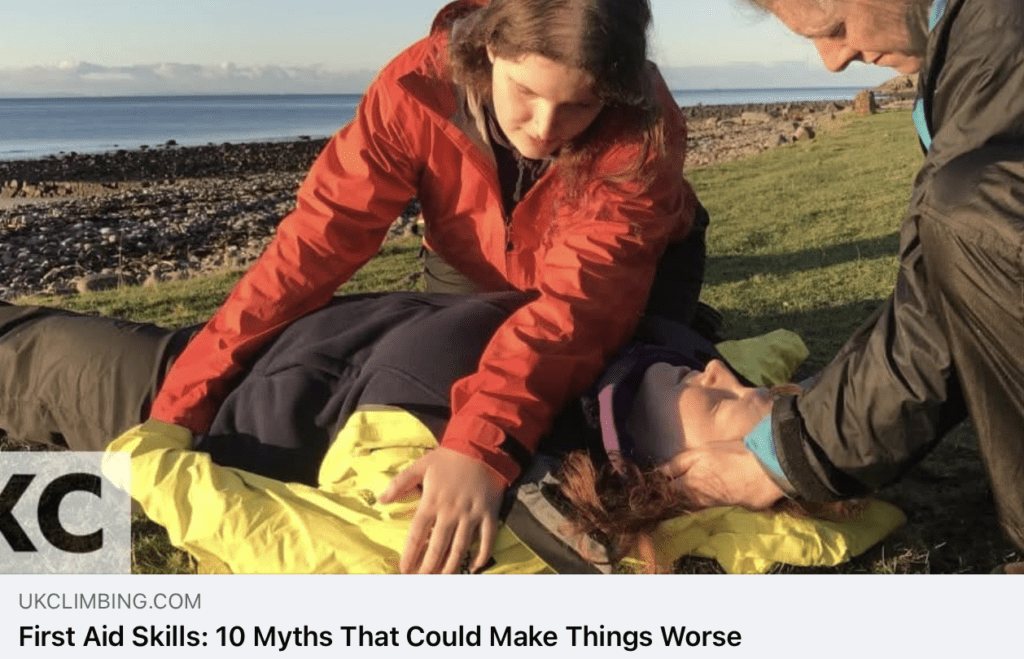 Two people supporting a casualty with possible neck or spine injury outdoors