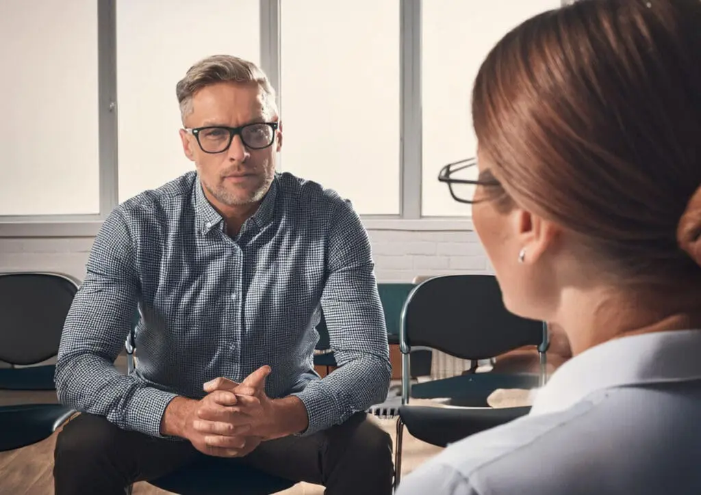 A male and female office worker in a counselling session in an office location
