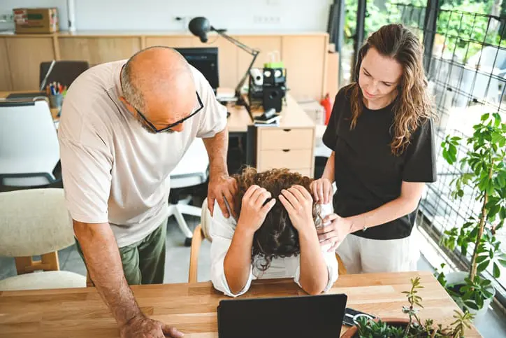 workers in the office console their colleague
