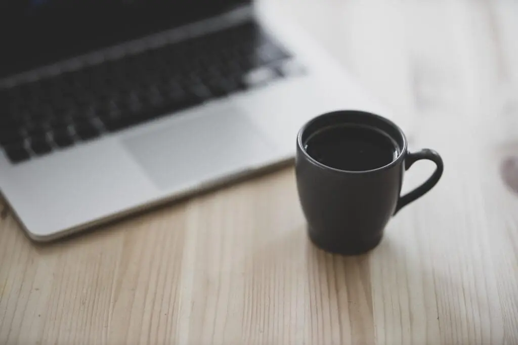 coffee cup and laptop on a desktop
