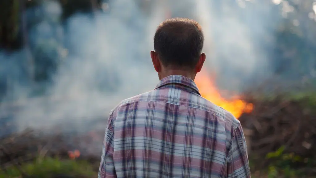A man looking towards a wildfire