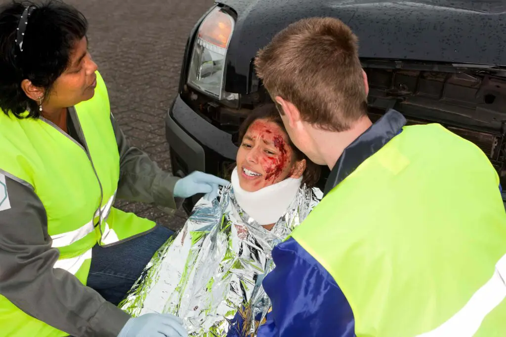 A woman with facial injuries being attended to by first aiders